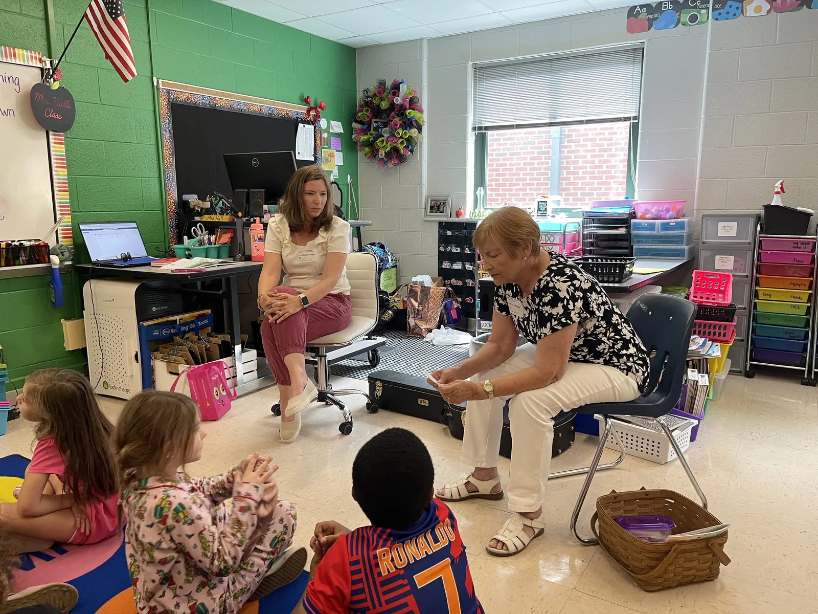 Gloria Taylor Crone talks with students after playing guitar, with Brandy Taylor Strzelecki looking on